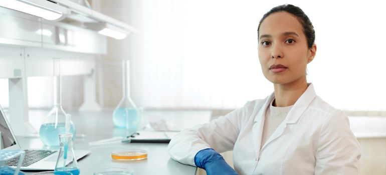 a female scientist in white lab coat working in a laboratory and thinking about peptide terminology