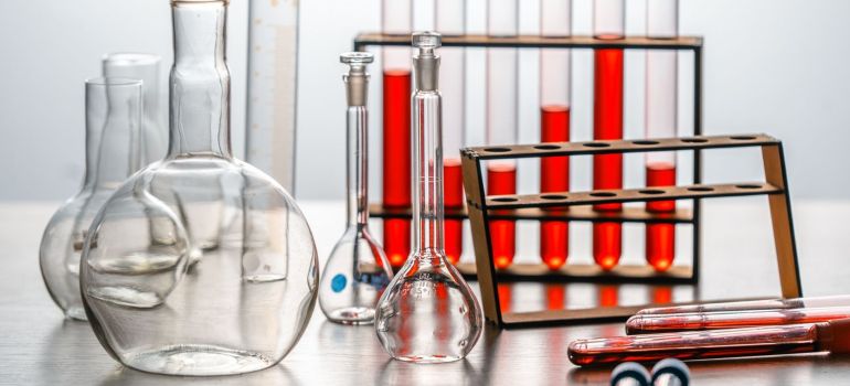 a close-up of various lab glassware with red liquids